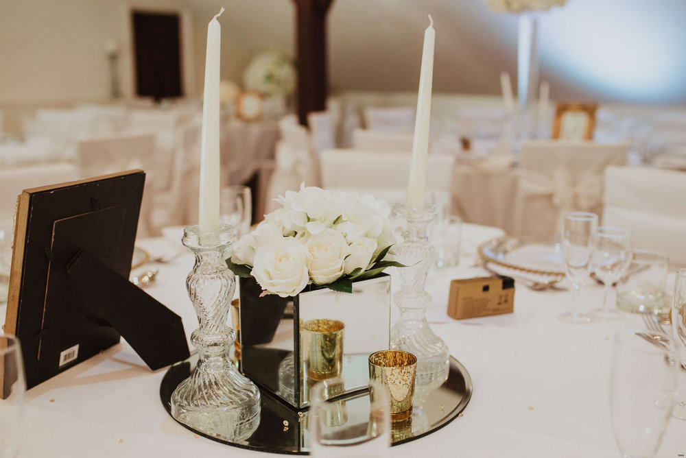 Elegant table setting for a wedding with white roses, mirror centerpiece
