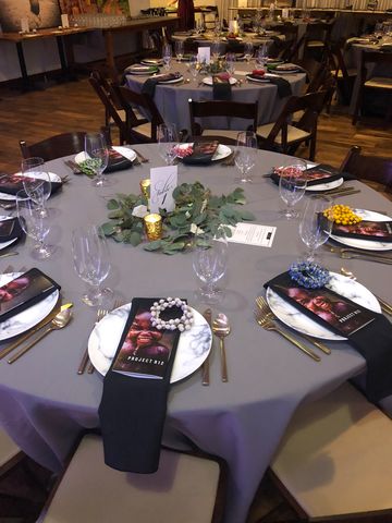 Round table with a gray tablecloth, white plates, bllack napkins and a handout about Project R12, 660 LaFayette Horton Events Downtown Nashville