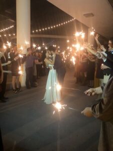 Fletcher couple kissing while guests hold sparklers Fletcher couple kissing while guests hold sparklers