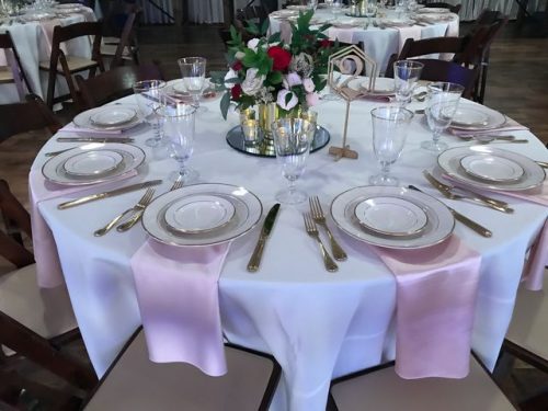 Round table with baby pink satin napkins, white dishes with platinum edges, silver cutlery and crystal stemware, 660 LaFayette Horton Events Downtown Nashville