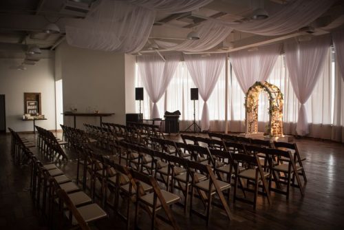 Wedding chairs and a wedding arch with lights. Beautiful wood floor at 660 LaFayette Street, Horton Events Downtown Nashville