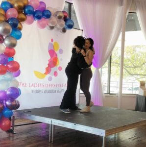 Fitness speaker hugging a woman on stage, Ladies Lifestyle Affair - Horton Events Downtown Nashville
