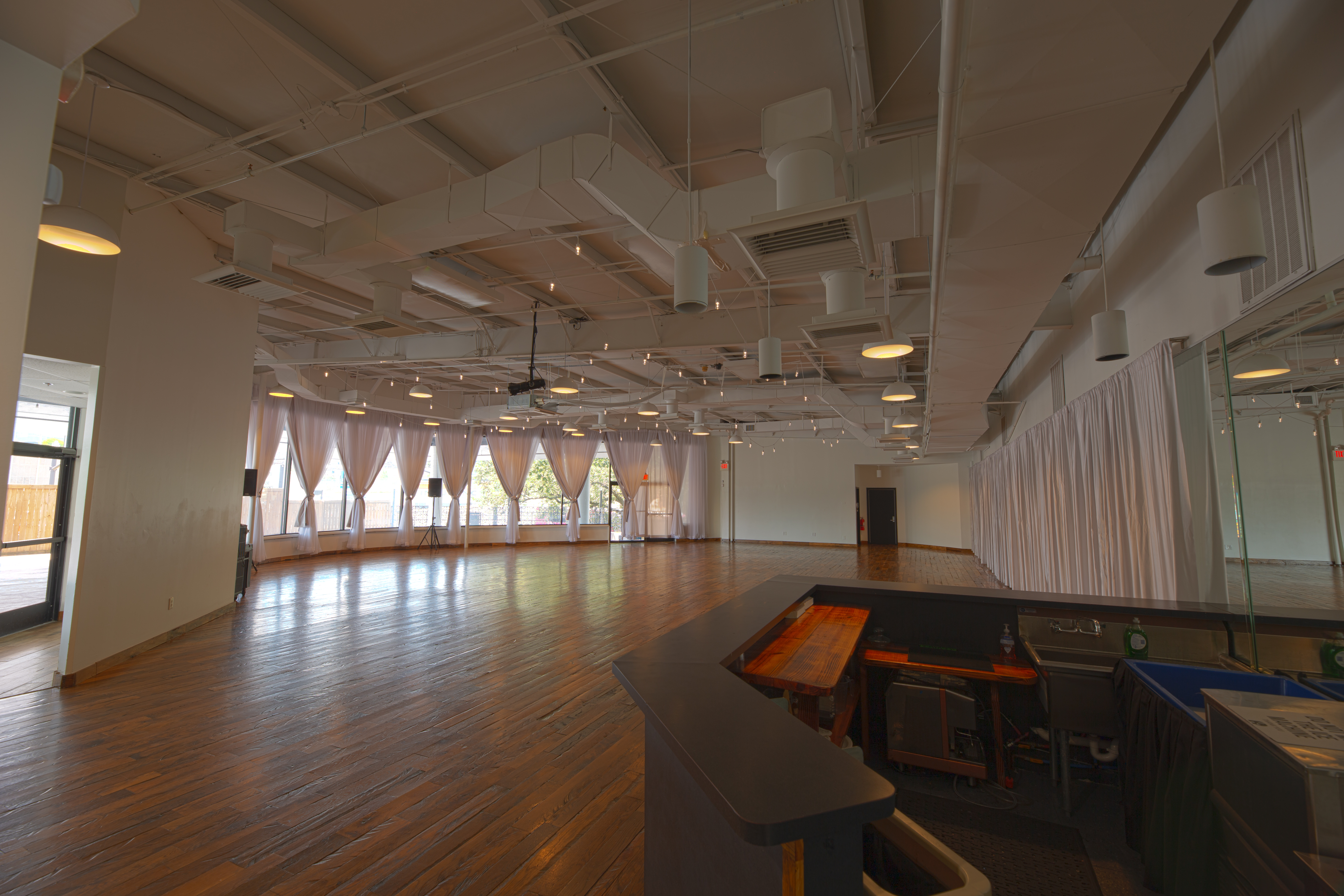 photo of the Main Showroom from the vantage point of the interior bar, showing the full room + the doorway